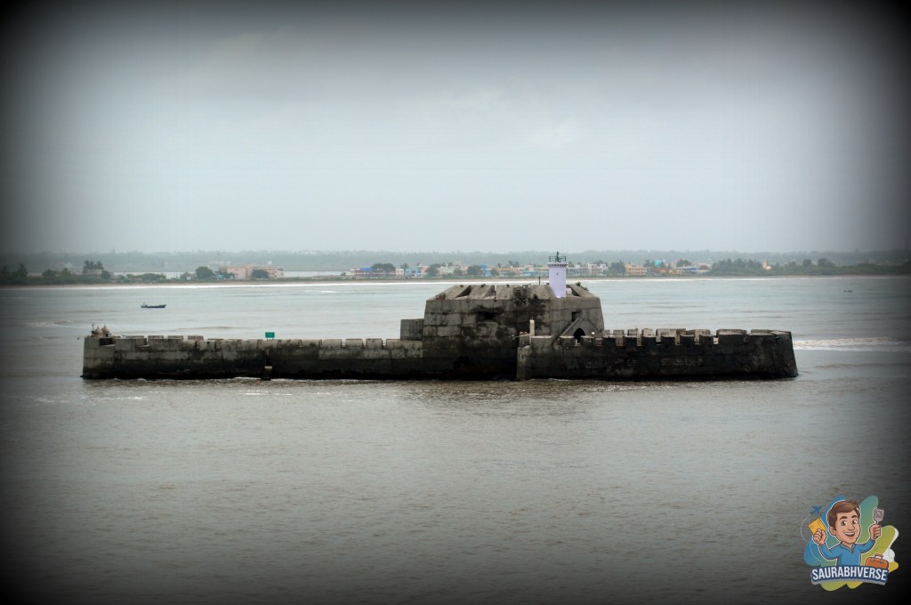 A historic sea fort, Pani Kotha, located in the water, surrounded by the Arabian Sea, with a cloudy sky in the background.