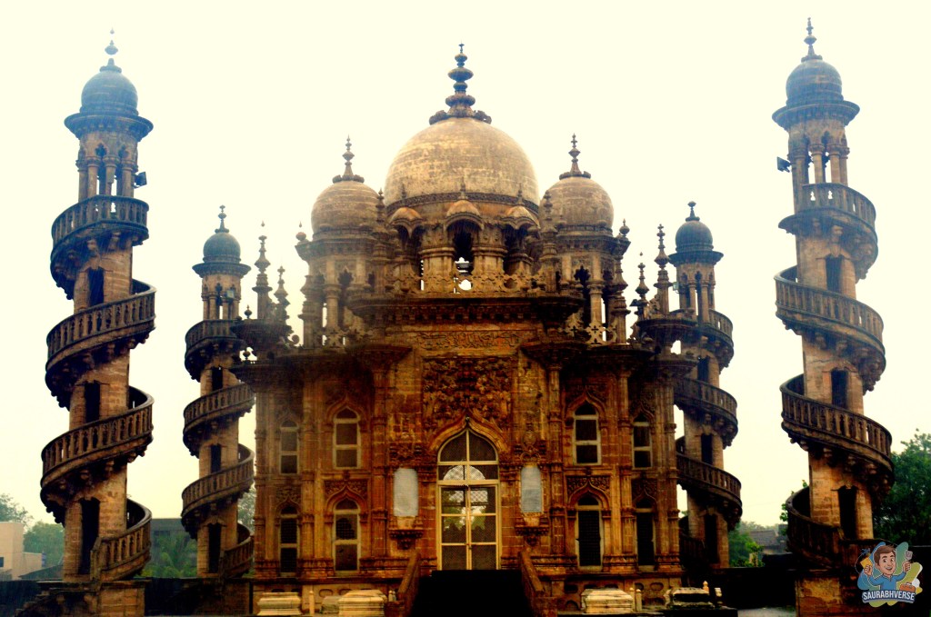 Mahabat Maqbara featuring intricate Indo-Islamic architecture with spiral minarets and domes, set against a cloudy sky.